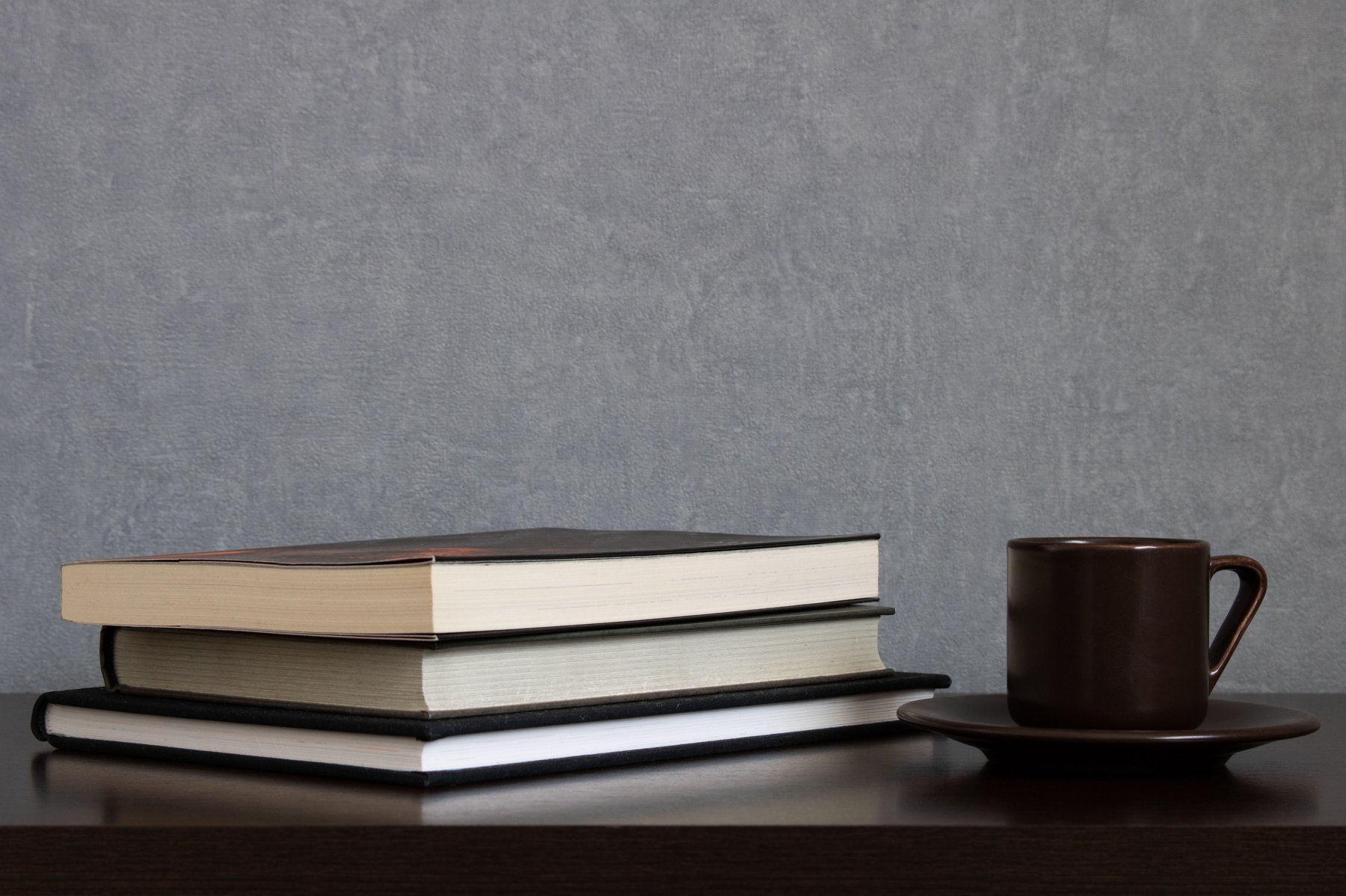 A still life of books and a warm cup in a quiet reading room